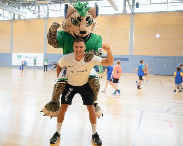 Lucas Krzikalla und Maskottchen BalLEo im Handballcamp des SC DHfK Leipzig. 